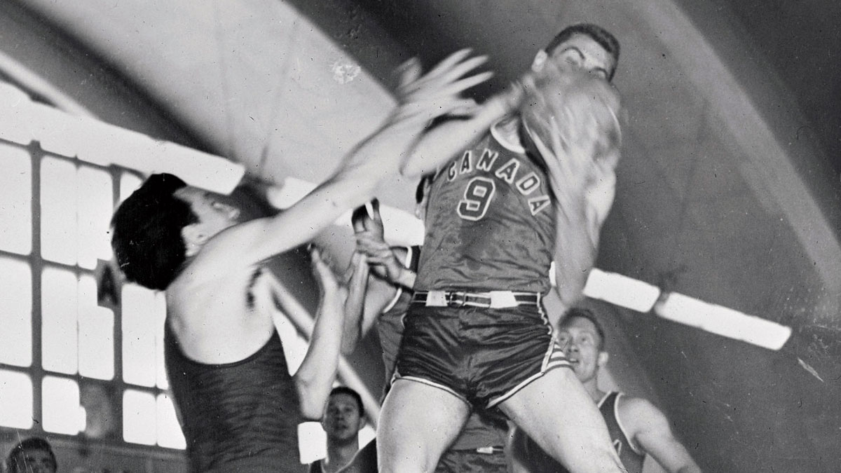 Canada Basketball at 1952 Olympics games in Helsinki, Finland. Canadian basketball player Bob Phibbs grabs rebound versus Italy