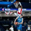 Canadian guard Elijah Fisher hangs on the rim after throwing down an emphatic dunk as Canada defeats Slovenia 90-69 to advance to the quarter-finals of the 2023 FIBA U19 World Cup.