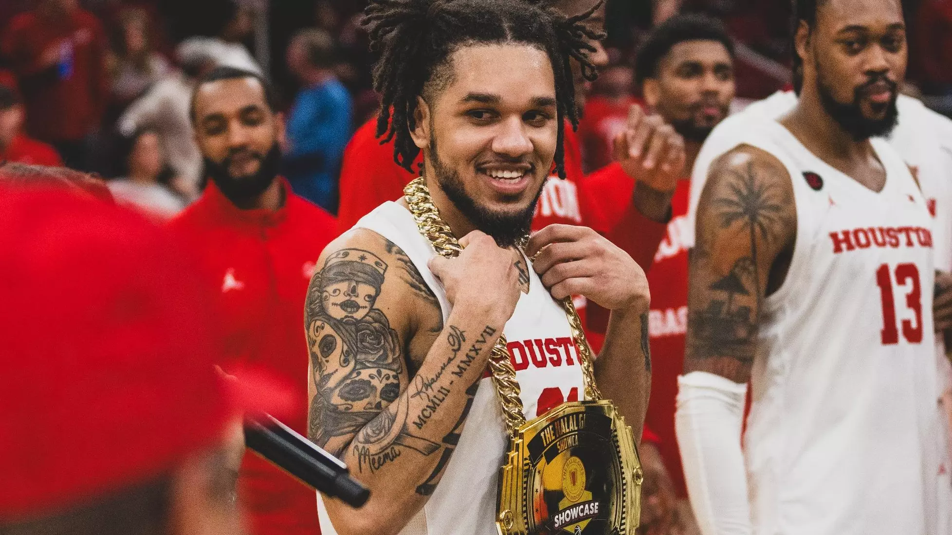 Houston cougars canadian guard emanuel sharp smiles to the camera while wearing championship belt