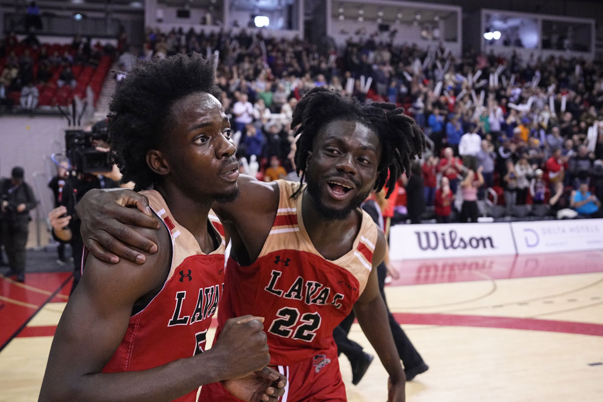Laval Rouge et Or guard Steeve Joseph (5) celebrates with teammate Baba Yao (22) following the shocking 75-69 win over top-ranked Victoria Vikes at the 2024 U Sports Final 8 Championships at the PEPS sports complex in Quebec City.