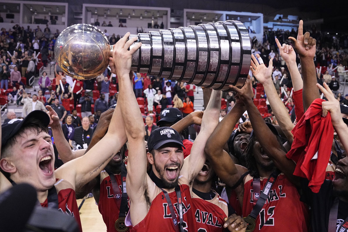Laval Rouge et Or hoist the WP McGee Trophy after defeating the Queens Gaels to win the 2024 U Sports men's basketball championship in Quebec City.