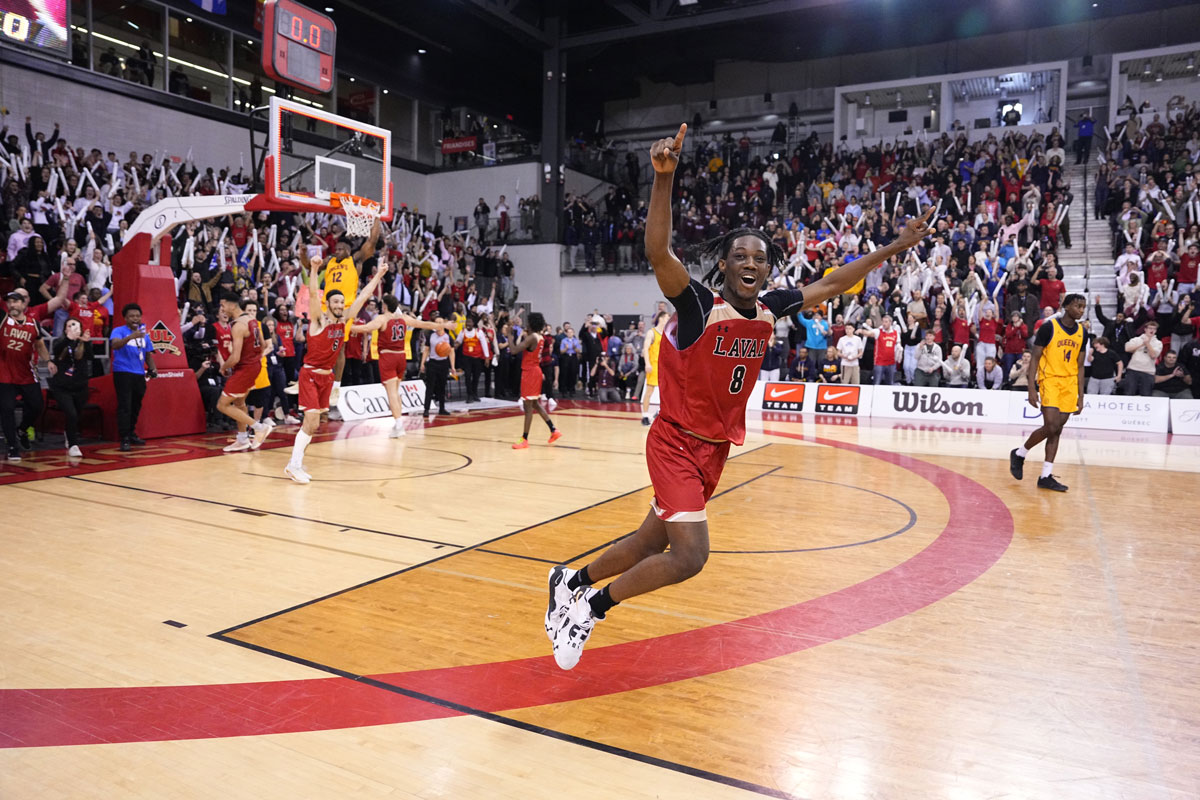 Laval rouge et or jayden larosiliere celebrates and points to rafters after defeating queens to win their first u sports mens basketball championship