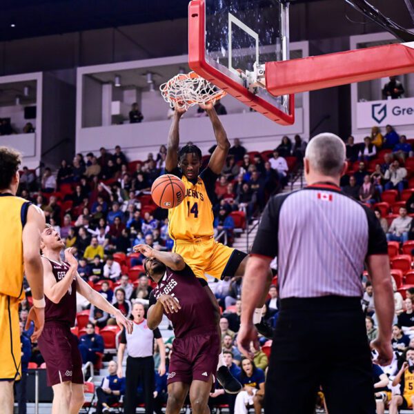 Michael Kelvin throws down an alley-oop slam over Jacques Melaine-Guemeta to help the Queens Gaels punch their ticket to their first U Sports Final 8 championship with an 84-77 win over the Ottawa Gee-Gees.