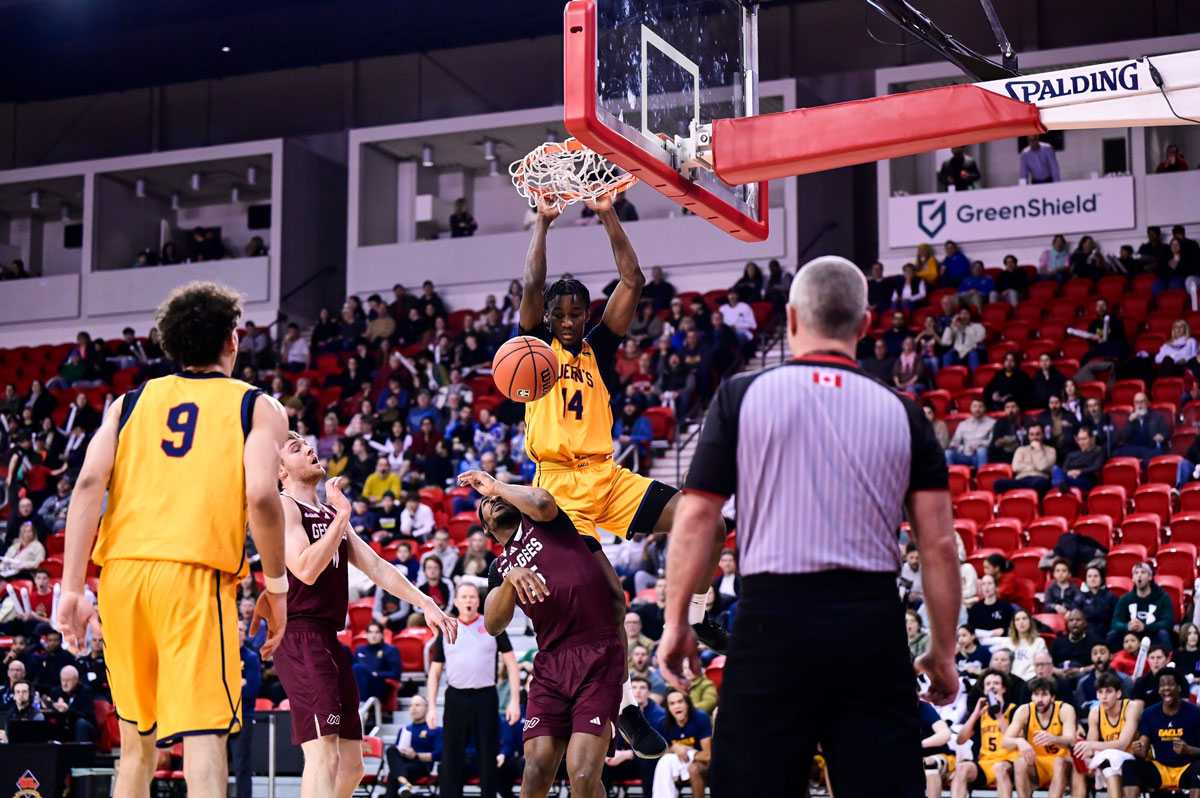 Michael Kelvin throws down an alley-oop slam over Jacques Melaine-Guemeta to help the Queens Gaels punch their ticket to their first U Sports Final 8 championship with an 84-77 win over the Ottawa Gee-Gees.