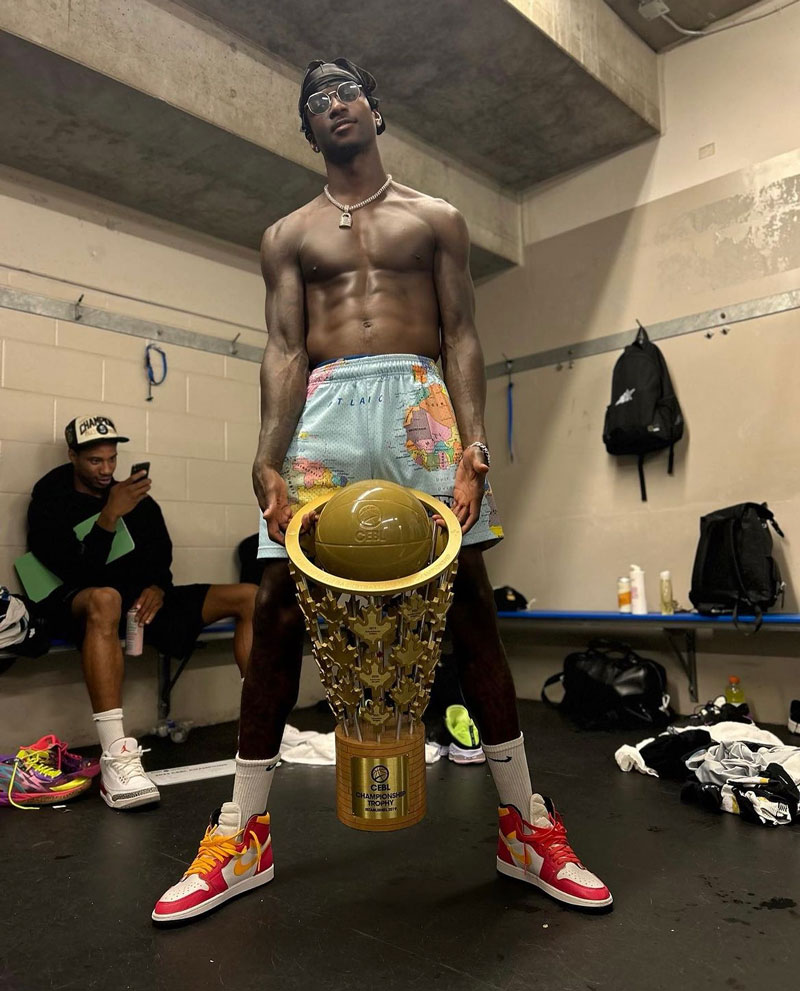 Myck Kabongo holding the CEBL championship trophy in the locker room.