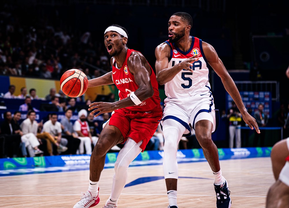 Shai Gilgeous-Alexander dribbles the basketball while being tightly guarded Mikal Bridges during the third-place game of the 2023 FIBA World Cup.