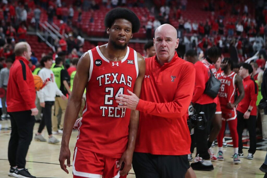 Texas tech assistant coach dave smart walks off the court with former player kerwin walton