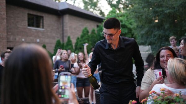 Zach edey pops a bottle of champagne after being drafted ninth overall by the memphis grizzlies
